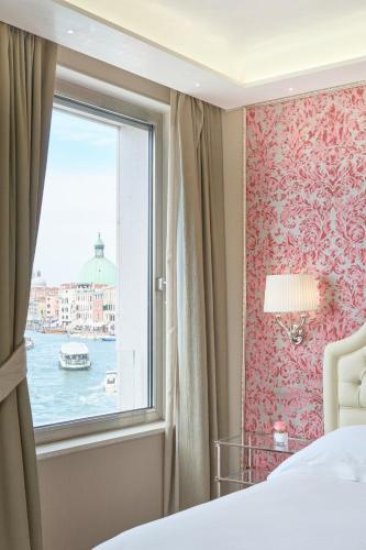 a bedroom with a window with a view of the water at Hotel Santa Chiara in Venice