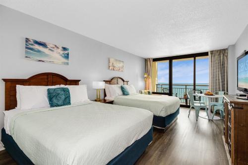 ein Hotelzimmer mit zwei Betten und Balkon in der Unterkunft WINTER RATES! OceanviewStudio Full Kitchen, Dogs OK! 1128 in Myrtle Beach