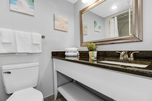 ein Badezimmer mit Waschbecken, Toilette und Spiegel in der Unterkunft WINTER RATES! OceanviewStudio Full Kitchen, Dogs OK! 1128 in Myrtle Beach