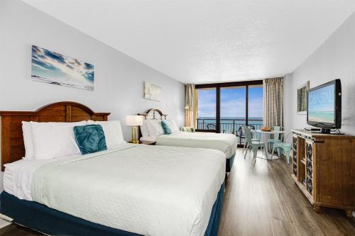 a hotel room with two beds and a flat screen tv at OceanviewStudio Full Kitchen, Dogs OK! 1128 in Myrtle Beach