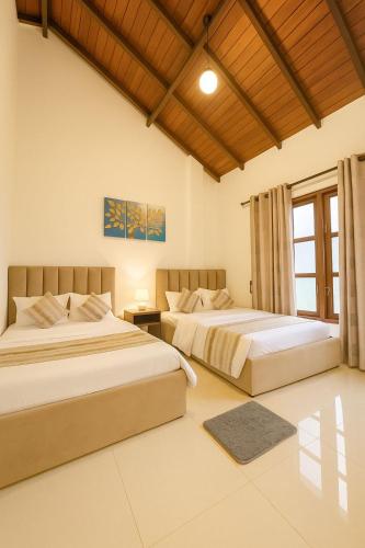 a bedroom with two beds and a window at Bloomingdale Bungalows - Nuwaraeliya in Sita Eliya