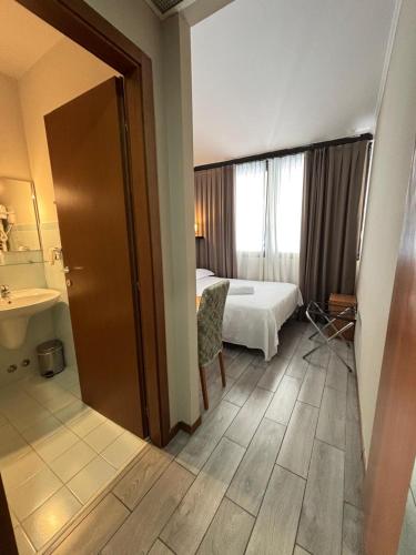 a hotel room with a bed and a bathroom at Hotel Garda in Affi