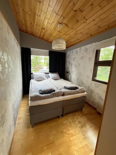 a bedroom with a bed with a wooden ceiling at Semi-detached cottage by the lake in Jyväskylä