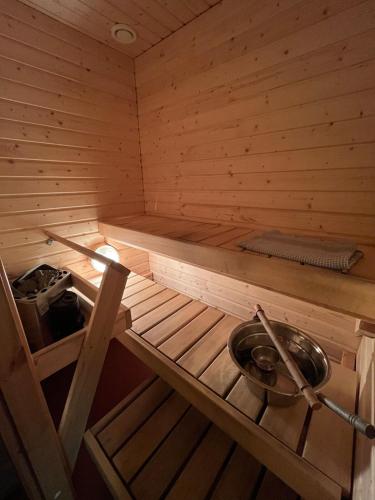 a inside of a wooden sauna with a bowl at Semi-detached cottage by the lake in Jyväskylä