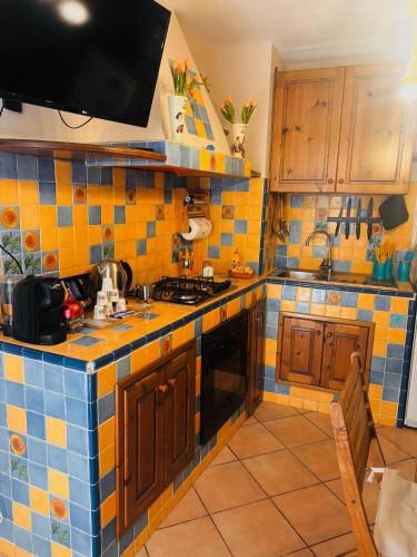 a kitchen with yellow and blue tiles on the counters at La casetta di Nonna Rosa in Santa Domenica