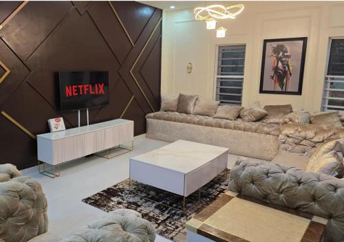 a living room with couches and a tv at Haven Height Executive Luxury Apartment in Lekki