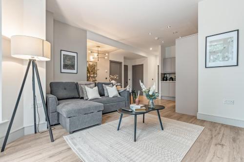 una sala de estar con un sofá y una mesa en Luxury 2 Bed Terraced Apartment In Slough, en Slough