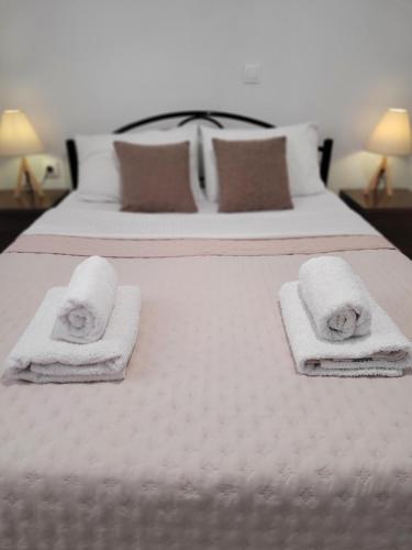 two beds with white towels and pillows on them at Center River Apartment in Florina