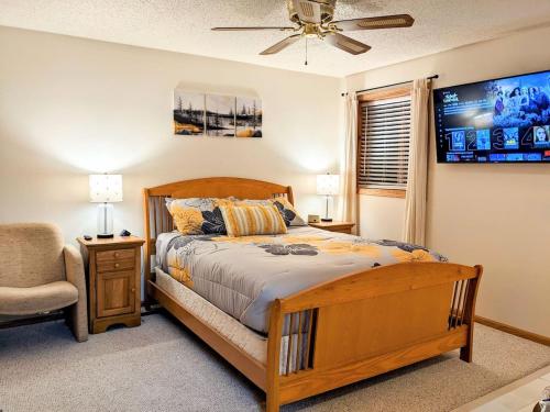 a bedroom with a wooden bed and a chair at UpperDells Riverfront Jacuzzi, Pool and Hot Tub in Wisconsin Dells