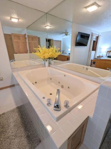 a large white bathroom with a large tub at UpperDells Riverfront Jacuzzi, Pool and Hot Tub in Wisconsin Dells
