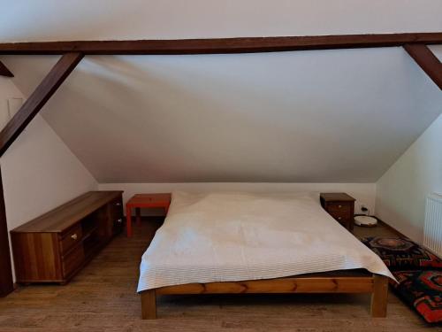 a bedroom with a bed and wooden furniture in a attic at Winnica Brochów in Brochów