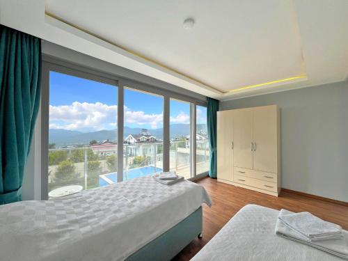 Un dormitorio con dos camas y una gran ventana. en Villa Panorama View Oludeniz, en Fethiye
