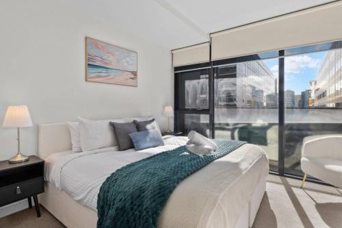 a bedroom with a bed and a large window at Serrata - 2B2B Docklands Apt Parking Available in Melbourne