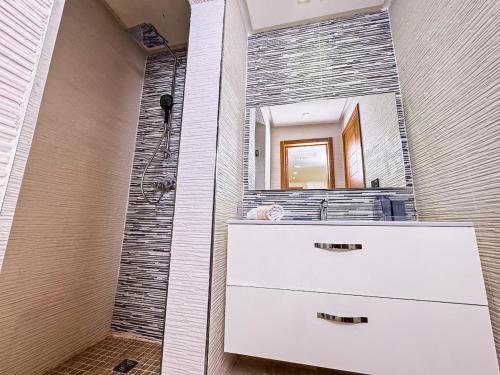 伊米乌阿达尔Oceanfront Gem and Beach Access的带水槽和带镜子的淋浴的浴室