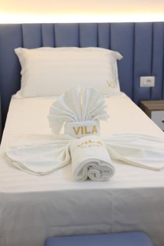a white bed with towels and avisorvisorvisorvisor at Villa Osmani in Shkodër