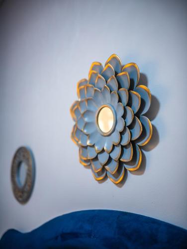 a wall mounted mirror with a flower on a wall at Home For You in Gaborone