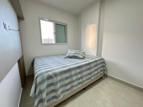 - une petite chambre avec un lit et une fenêtre dans l'établissement Apto Alto Padrão Aviação 2Qts (1Suíte), à Praia Grande