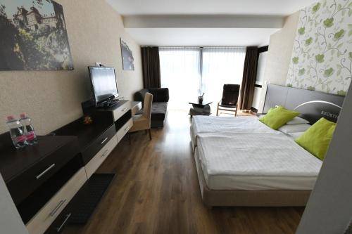 a hotel room with a bed and a television at Ezüsthíd Hotel in Veszprém