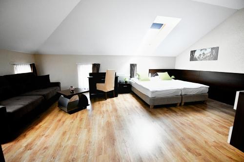 a living room with a bed and a couch at Ezüsthíd Hotel in Veszprém