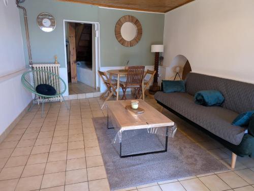un salon avec un canapé et une table dans l'établissement Petite maison à la campagne avec extérieur, à Paslières