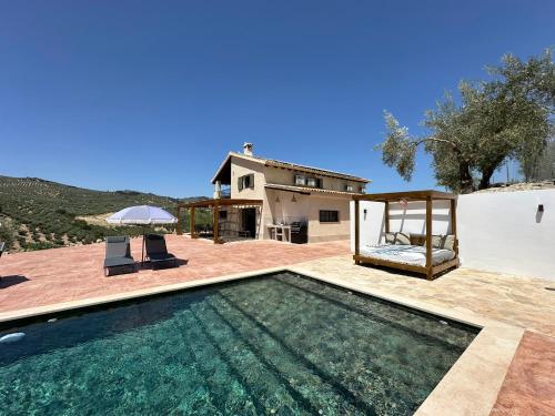 a villa with a swimming pool and a house at Casa Manuela in Montefrío