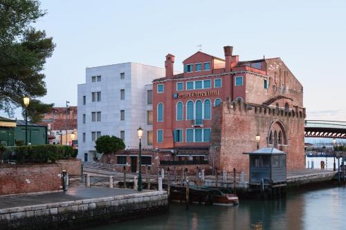 an old building next to a river with buildings at Hotel Santa Chiara in Venice