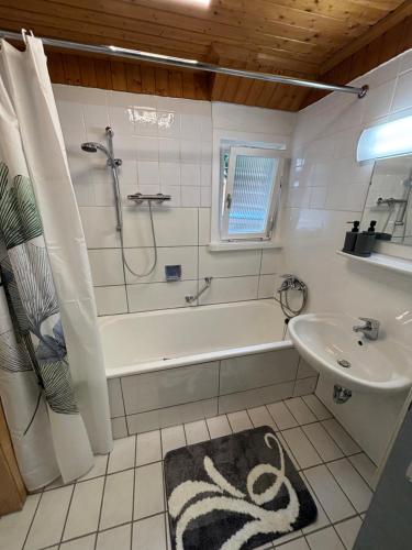 a bathroom with a bath tub and a sink at Murgtal Traum Apartment Schwarzwald in Baiersbronn