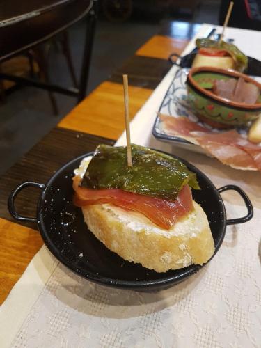 a sandwich on a black plate on a table at Casa Rural Lakoak in Garínoain