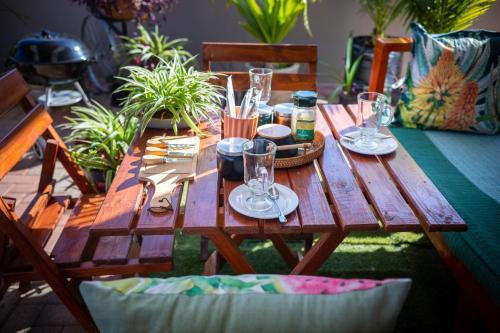 a wooden table with plates and glasses on it at Home For You in Gaborone