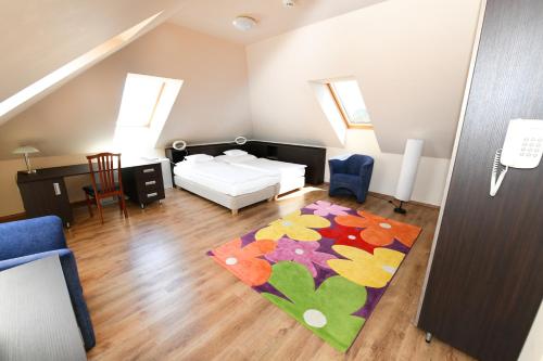 a living room with a bed and a rug at Ezüsthíd Hotel in Veszprém