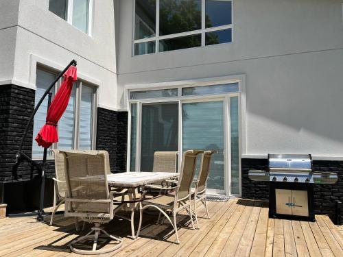 a patio with a table and chairs and a grill at Country Elegance Near GTA in Schomberg