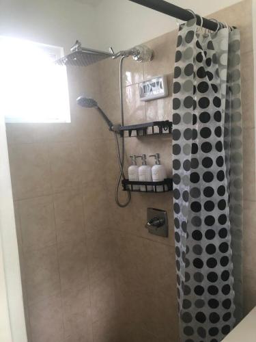 a bathroom with a shower with a black and white shower curtain at Cozy Escape in Charlestown