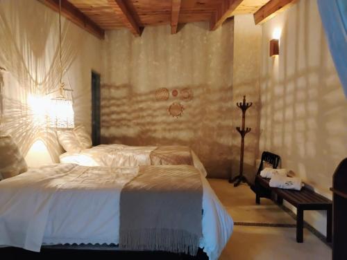 a bedroom with a white bed and a table at Paraje Real Malinalco in San Martín