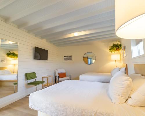 a bedroom with two beds and a tv at Driftwood Motel in Bay Saint Louis