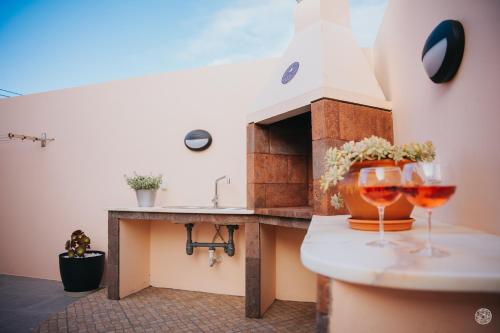 a kitchen with two glasses of wine on a counter at Casa da Carreira in Almagreira