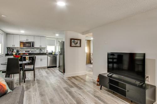 a kitchen and living room with a large flat screen tv at 2 Mi to USC Campus Peaceful Apartment with Yard in West Columbia