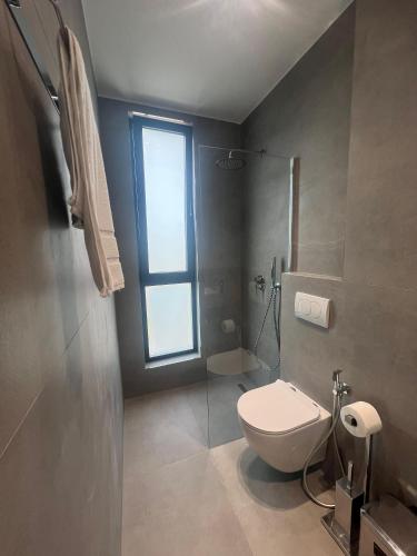 a bathroom with a toilet and a window at Hotel Sisana in Vlorë