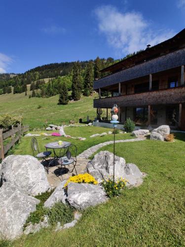 a garden with a table and chairs in front of a building at Gästehaus Oben am Berg in Balderschwang