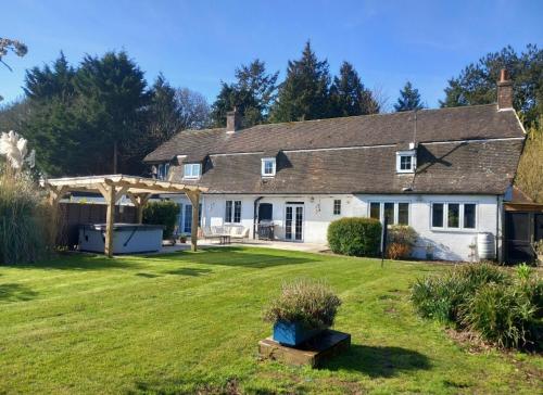 a large white house with a large yard at The Lodge - luxurious country stay with Hot tub, Games room and Gym in Canterbury