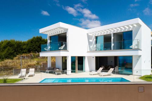 a white villa with a swimming pool at Villa das Neves in Estreito da Calheta