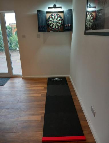 a room with a dart board on the wall at The Lodge - luxurious country stay with Hot tub, Games room and Gym in Canterbury