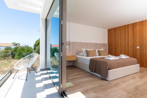 a bedroom with a bed and a sliding glass door at Villa das Neves in Estreito da Calheta