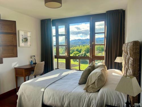 ein Schlafzimmer mit einem Bett und einem großen Fenster in der Unterkunft La casa roja de Ovio in Picones
