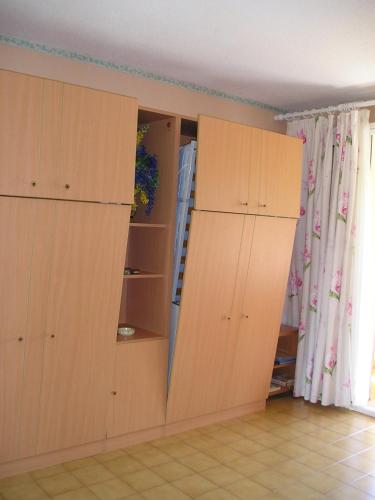 deux armoires en bois dans une pièce avec une cuisine dans l'établissement greoux eden 24, à Gréoux-les-Bains