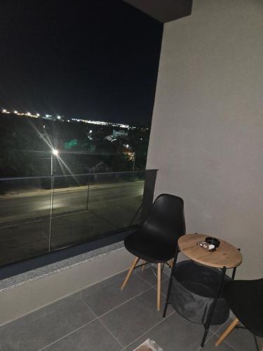 a room with a table and two chairs and a window at Lux Mimi Apartments in Skopje