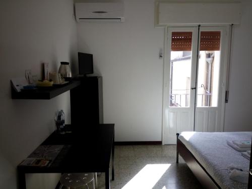 a room with a bed and a table and a window at L'Altra Modica Locazione Turistica in Modica