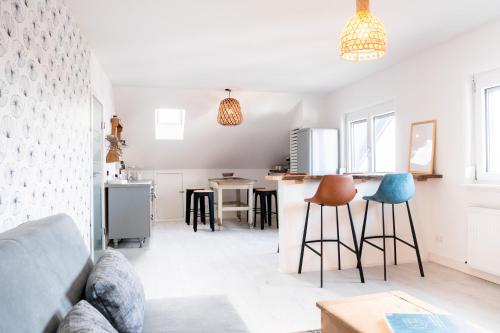 a kitchen and living room with chairs and a counter at Appartement Seeblick in Lindau