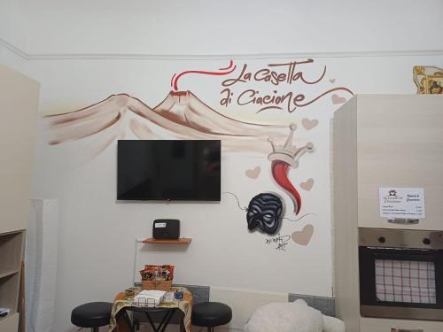 a living room with a tv on a wall at La casetta di Ciacione in Naples