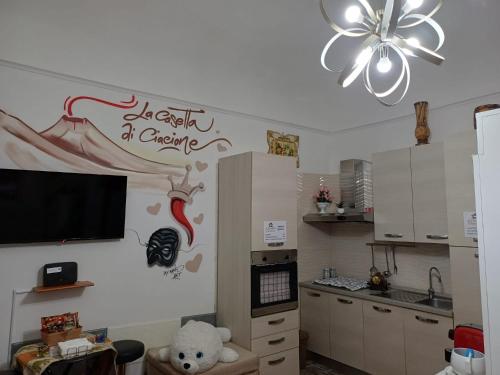a kitchen with a tv on the wall and a teddy bear at La casetta di Ciacione in Naples