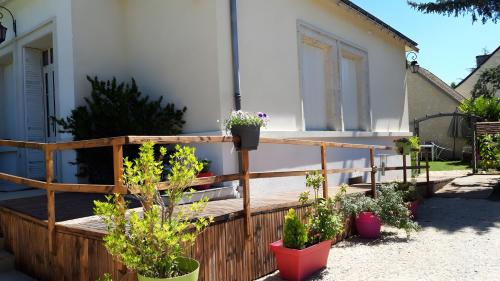 a wooden deck with potted plants in front of a house at Gite des Coteaux Pmr in Sainte-Maure-de-Touraine